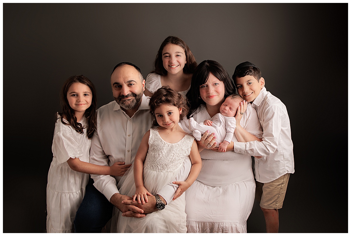 Family holds newborn close showing Why Newborn Photography is Worth the Investment