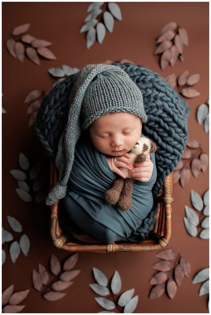 Baby lays wrapped in a blue blanket for Yaffa Koff Photography