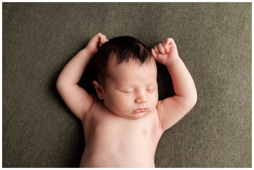 Baby lays with arms by their side for Yaffa Koff Photography