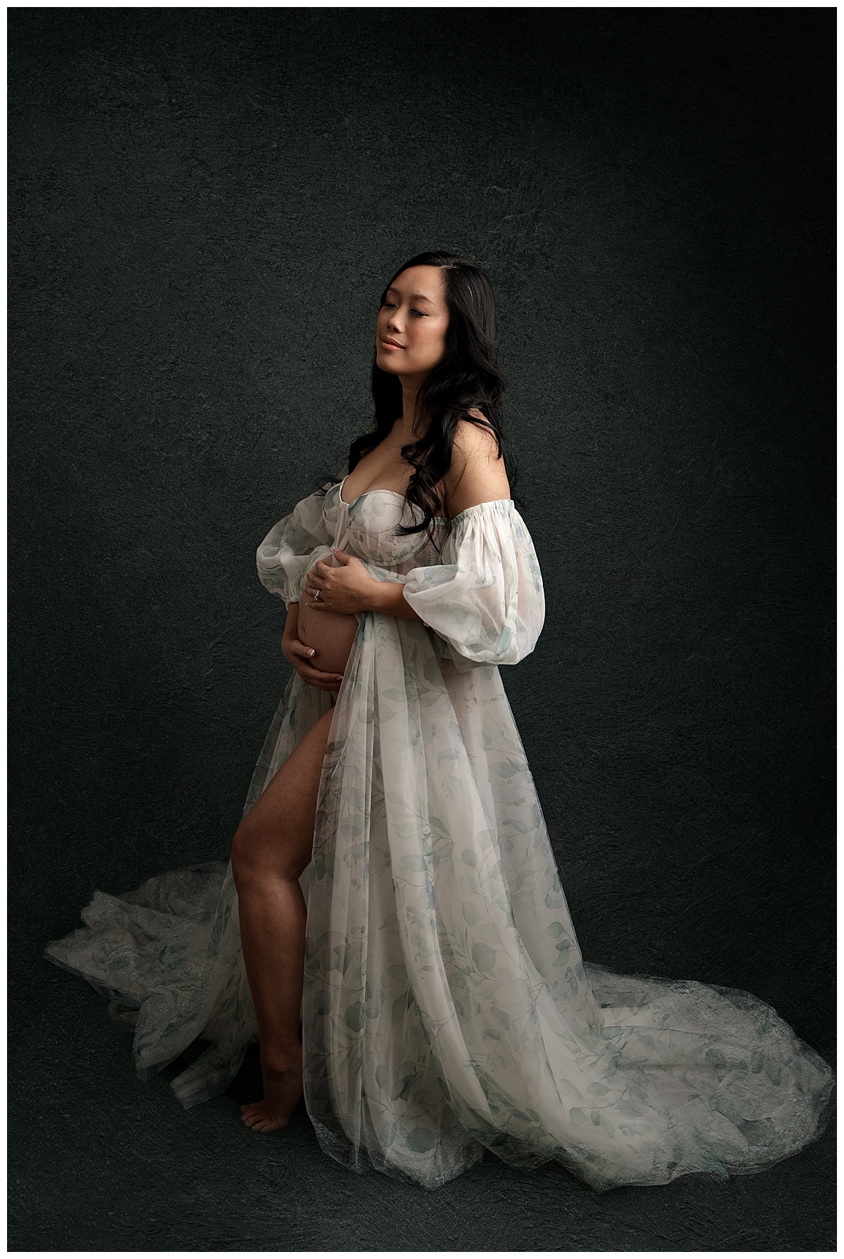 Woman looks beautiful embracing her pregnant belly showing Why I Include Hair And Makeup For All Maternity Sessions