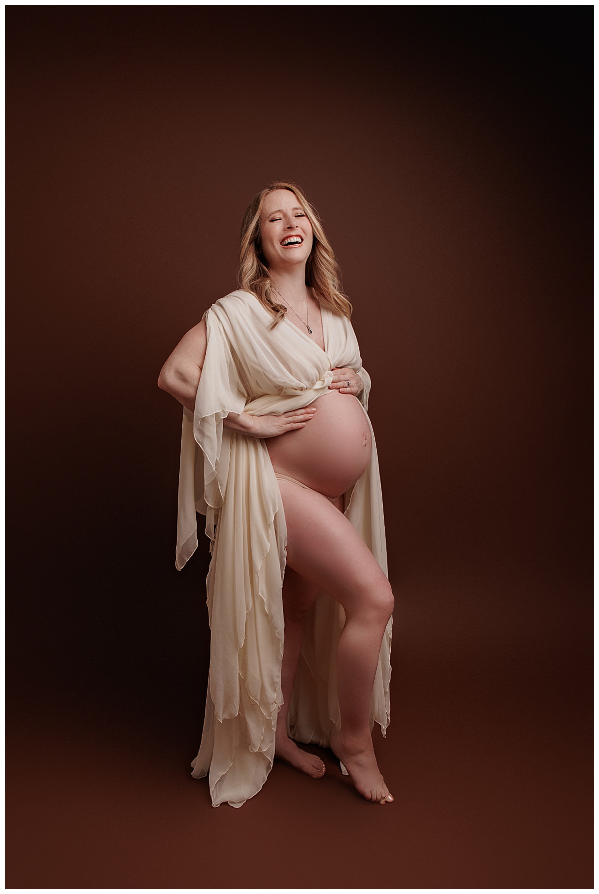 Woman looks beautiful holding onto her pregnant belly showing Why I Include Hair And Makeup For All Maternity Sessions