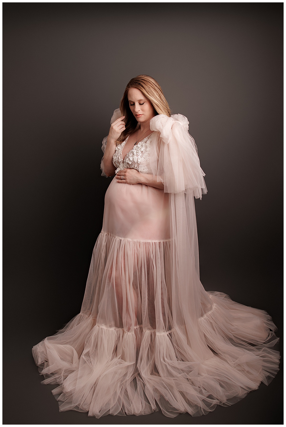 Adult wears stunning gown holding her hand on her pregnant belly for Yaffa Koff Photography