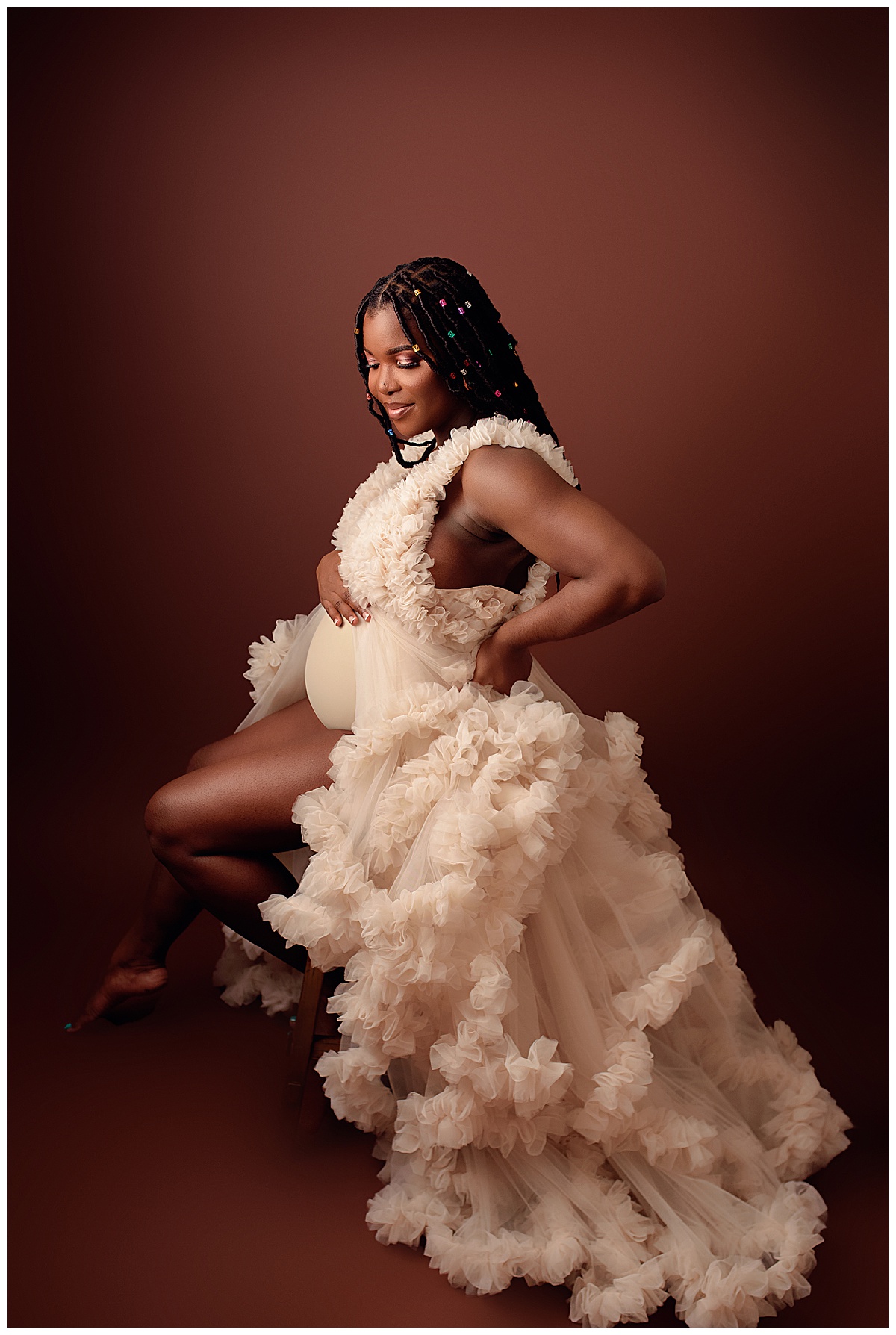 Adult sits down wearing a stunning gown for Silver Spring Maternity Photographer