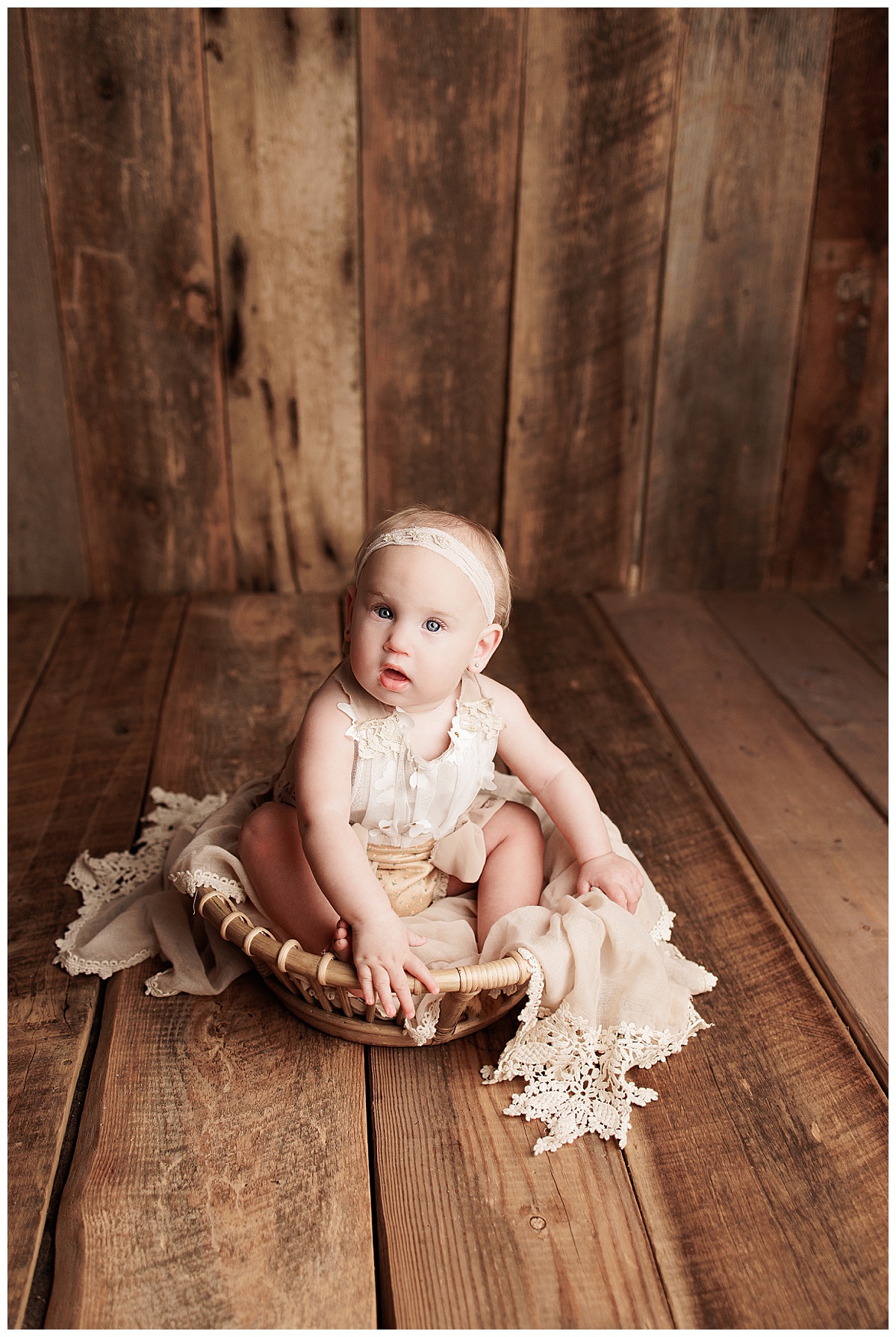 Young baby sits on the floor in a basket for Silver Spring Newborn Photographer