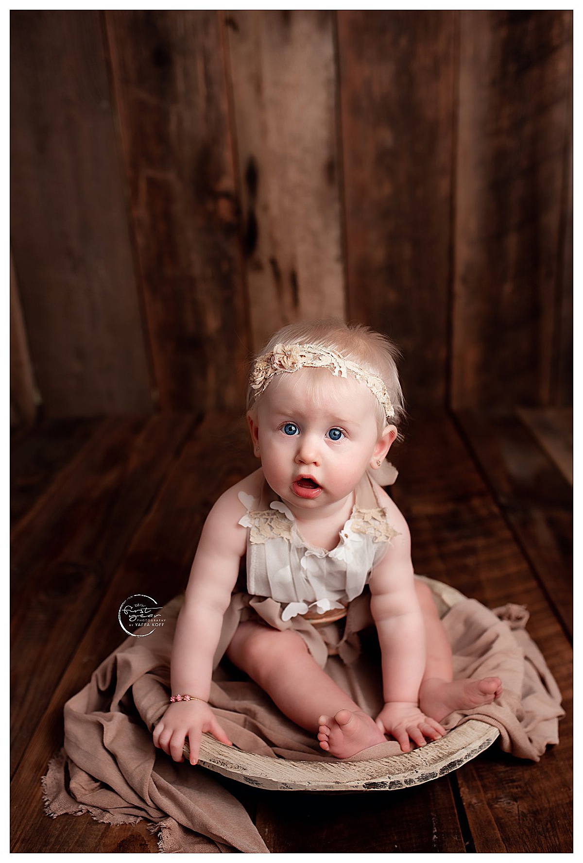 Baby sits in a basket on the floor for Yaffa Koff Photography