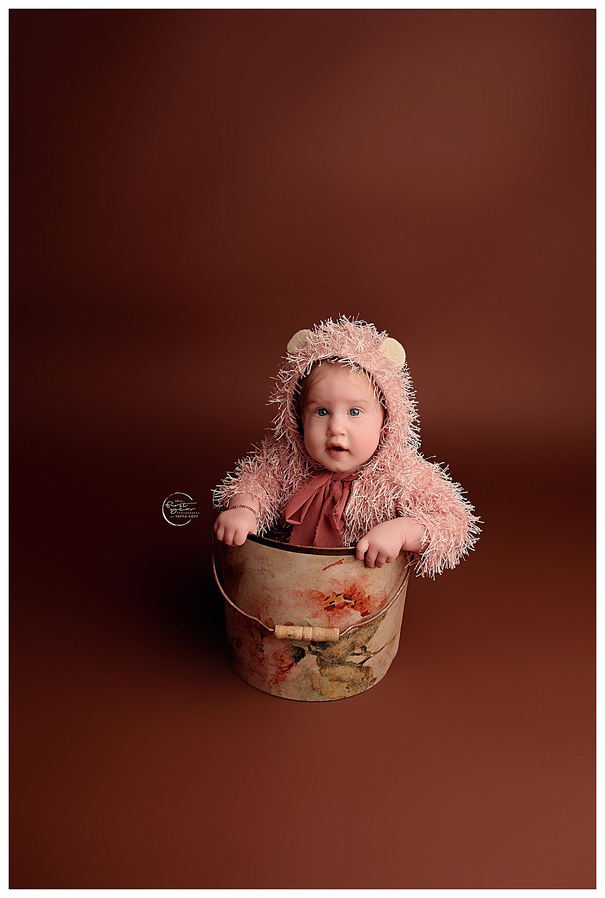 Baby sits in a a basket during her Baby Milestone Photos