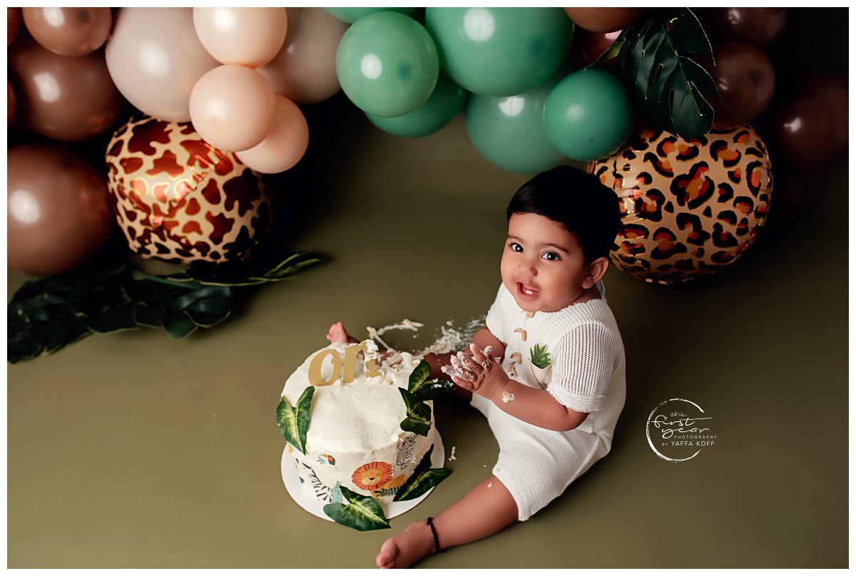 Baby sits and enjoys the cake during a Cake Smash session