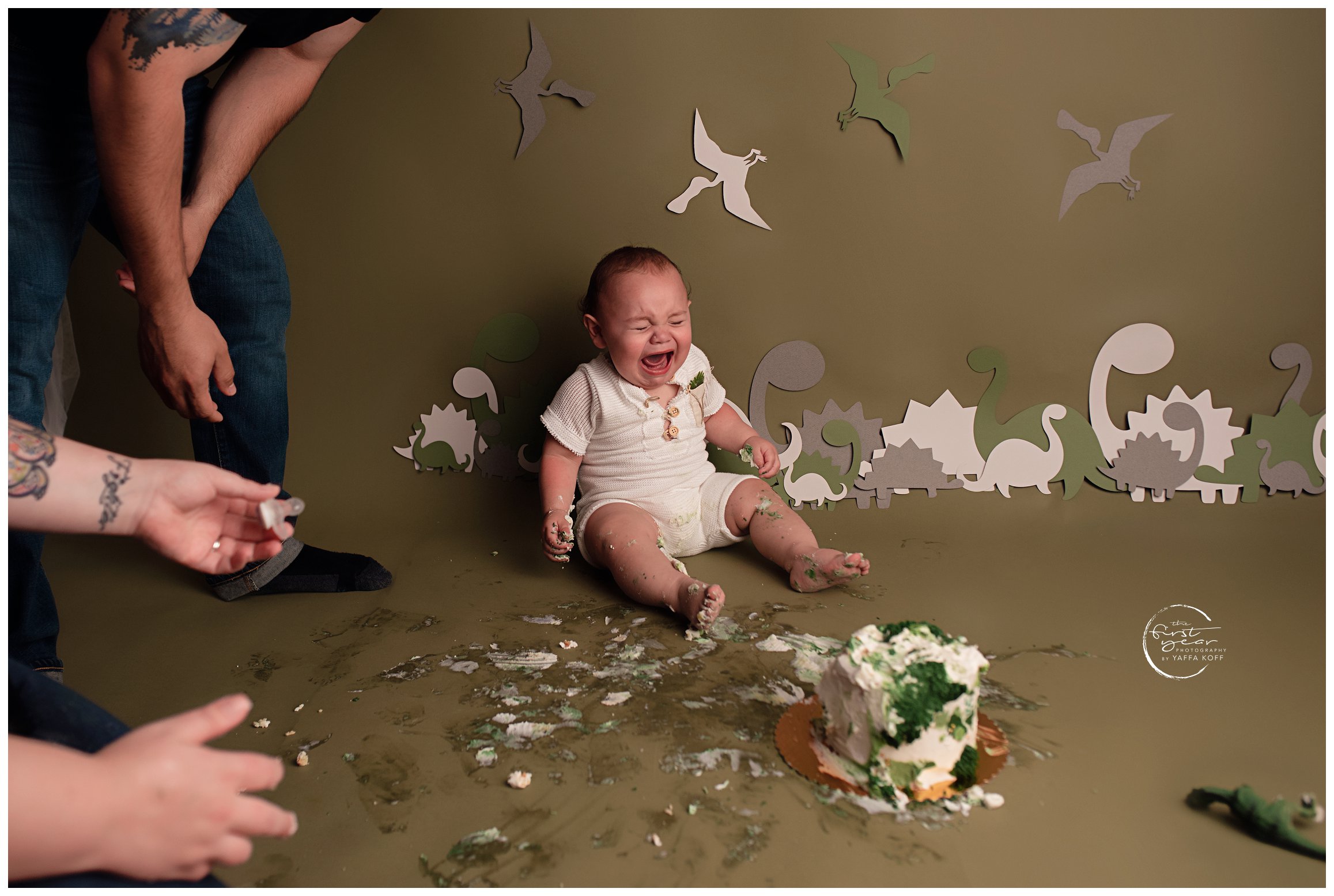 Baby sits down and cries during a Cake Smash session