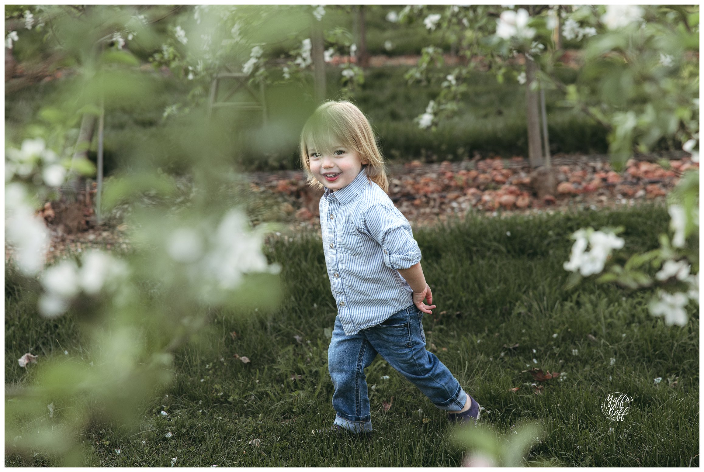 Child runs around and smiles during Family Portraits In The Spring 