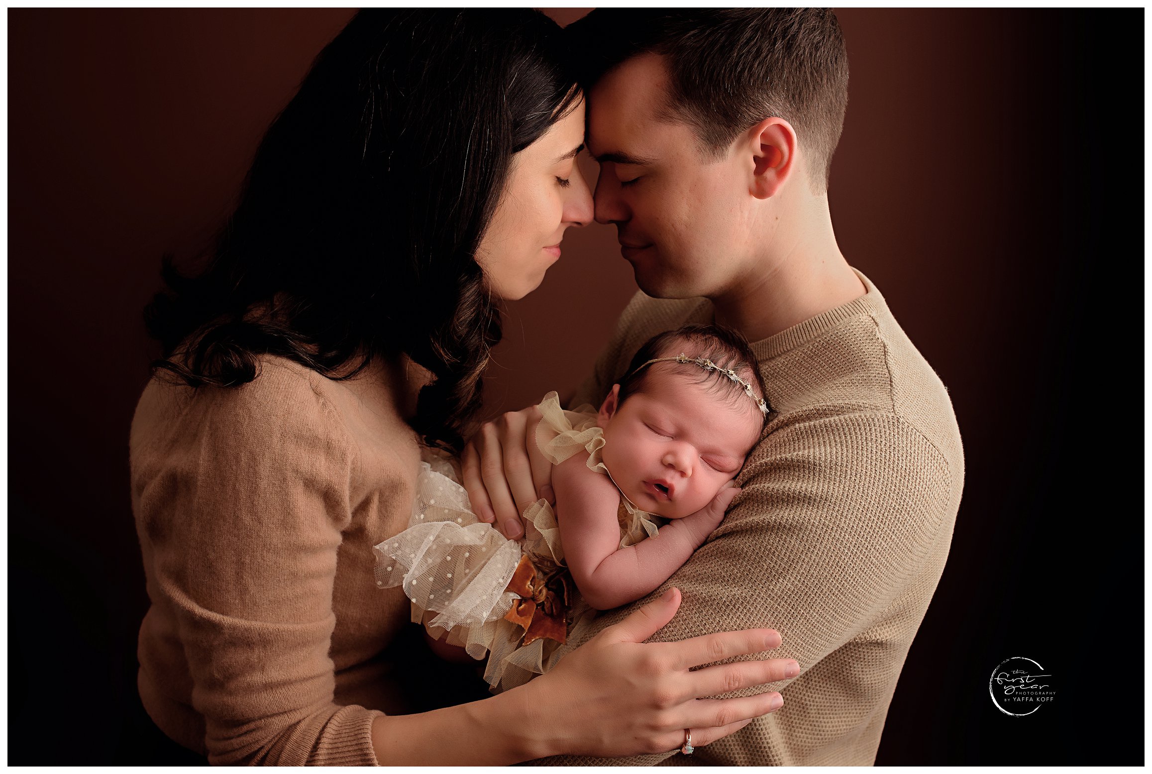 Parents hold and cuddle their baby for Norma Fayak Photography