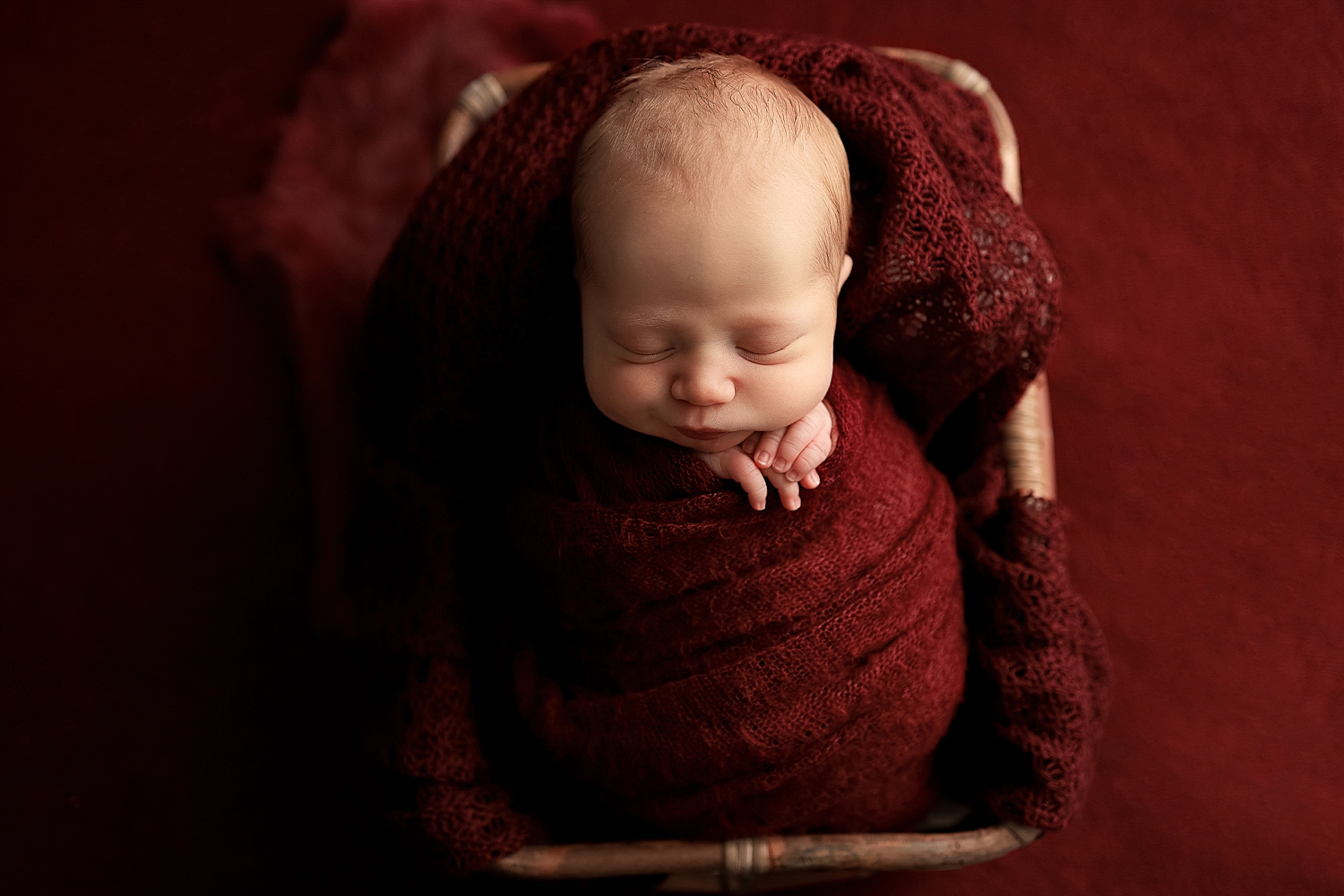 infant wrapped in red blanket for Fine Art by Yaffa Koff Photography