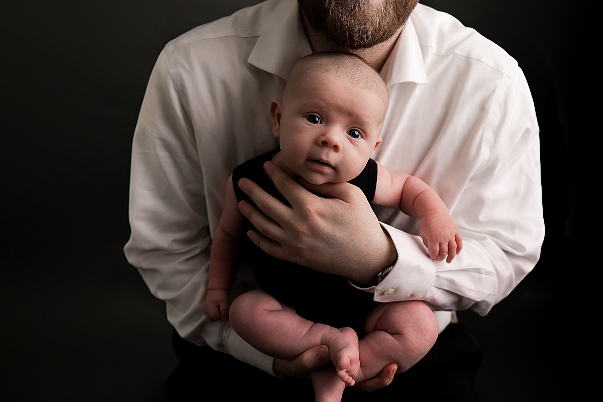 dad holding baby by silver spring newborn photographer