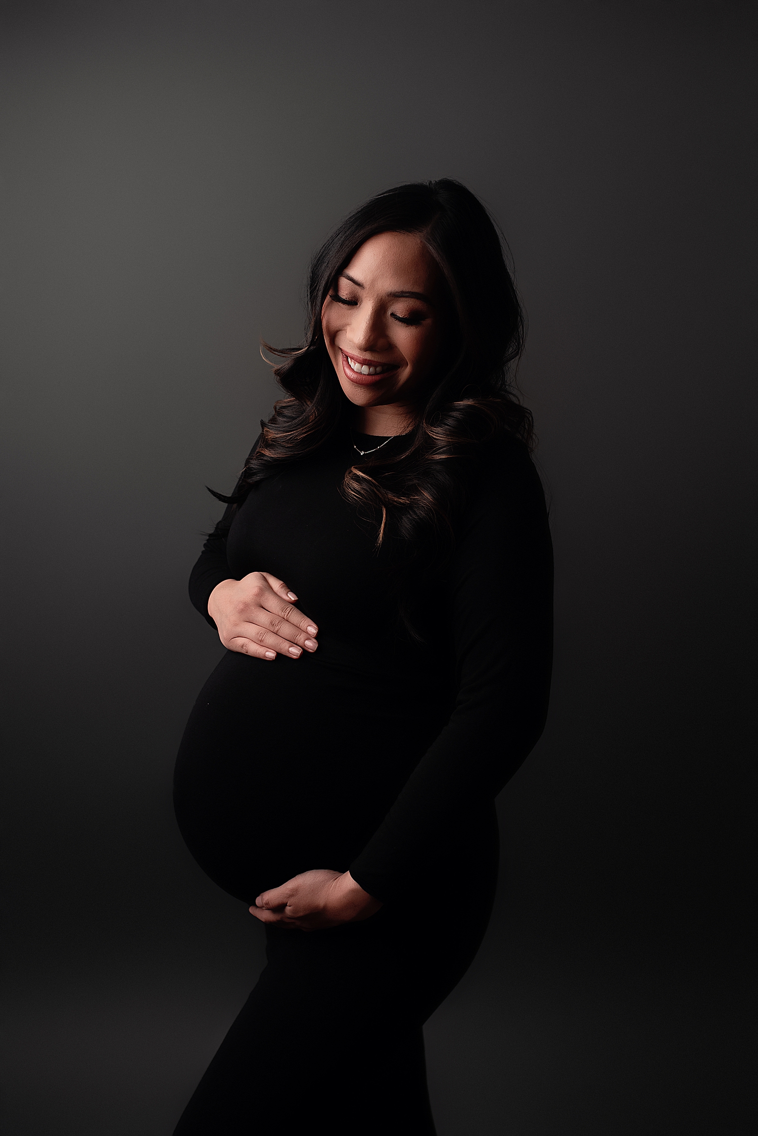 mama in black dress holds pregnant belly by Silver Spring Newborn Photographer