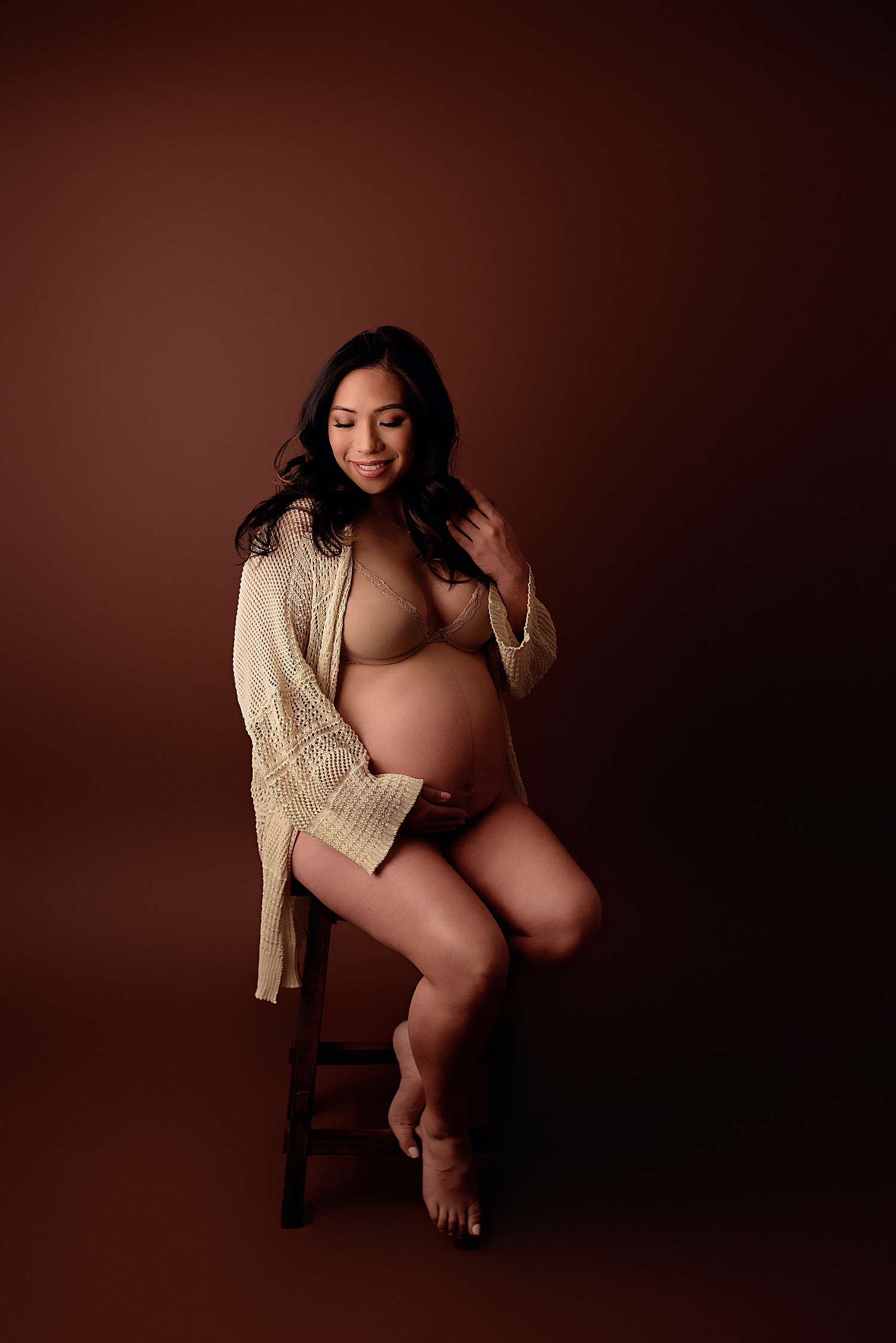 woman in knit cardigan demonstrates why professional maternity photography matters